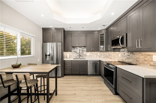 kitchen featuring light hardwood / wood-style flooring, stainless steel appliances, dark brown cabinets, and sink