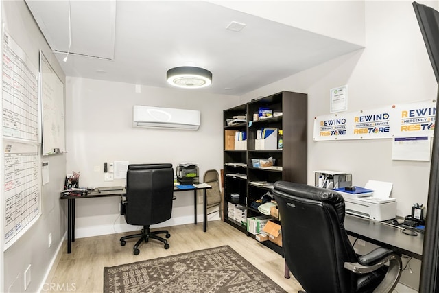 home office featuring light wood-type flooring and an AC wall unit