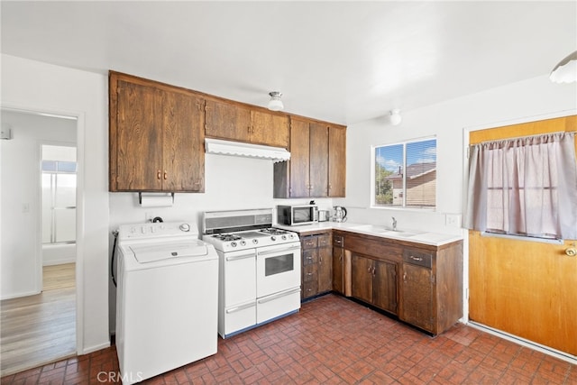 kitchen featuring sink, washer / dryer, and white gas range oven