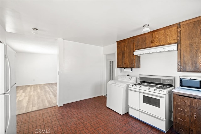 kitchen featuring white appliances, range hood, and washer / dryer