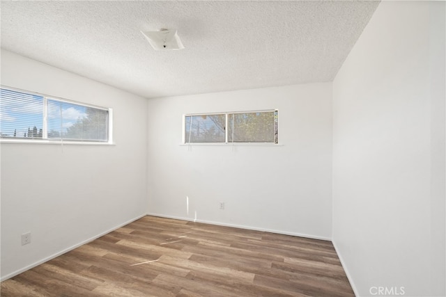 spare room featuring a textured ceiling and hardwood / wood-style floors