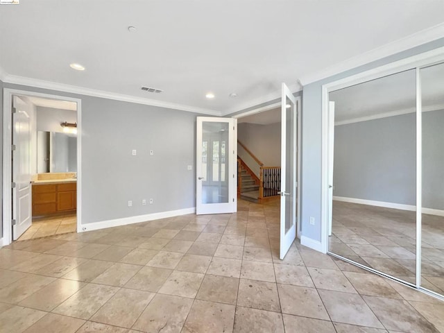 unfurnished bedroom featuring french doors, connected bathroom, a closet, and crown molding