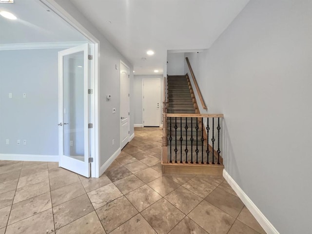 hall with light tile patterned floors and crown molding