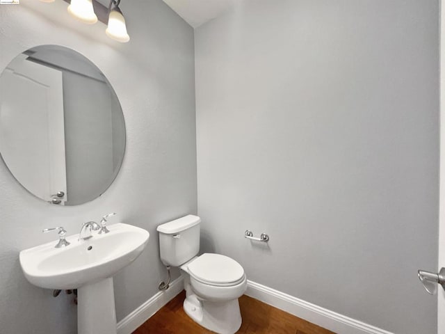 bathroom featuring sink, wood-type flooring, and toilet