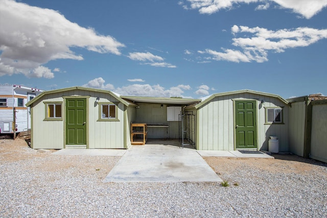 back of house featuring a storage unit and a patio area