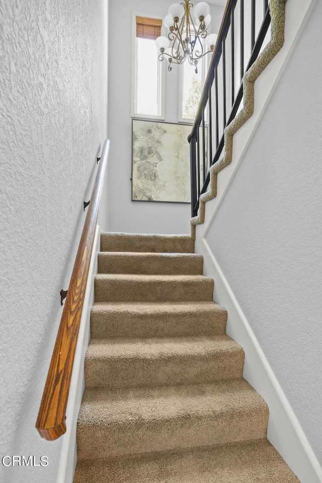 stairs with an inviting chandelier