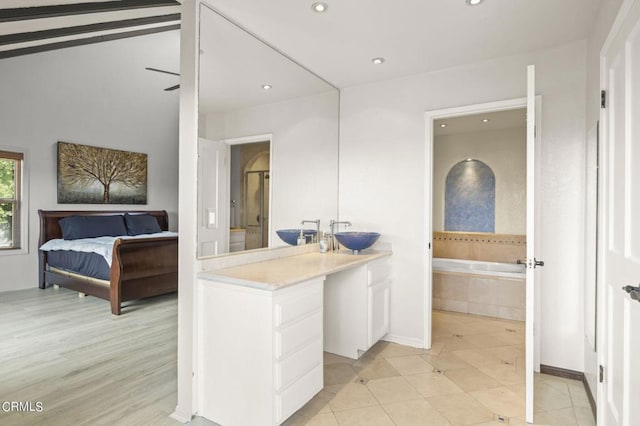 bathroom with vanity, a relaxing tiled tub, and wood-type flooring