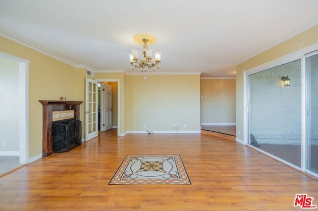 unfurnished living room featuring a notable chandelier, light hardwood / wood-style floors, and ornamental molding