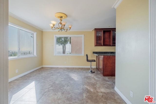 unfurnished dining area with a chandelier, crown molding, and a healthy amount of sunlight