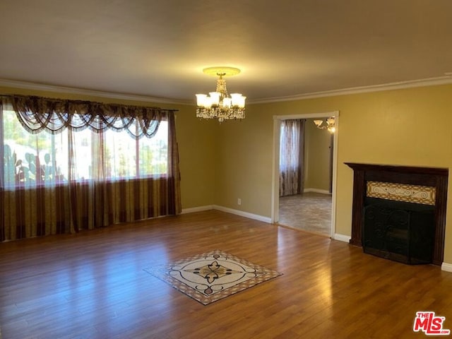 unfurnished living room featuring wood-type flooring, a notable chandelier, and ornamental molding