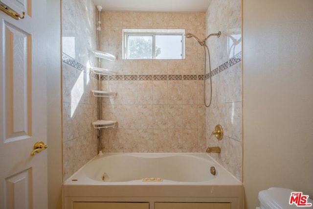 bathroom featuring toilet and tiled shower / bath