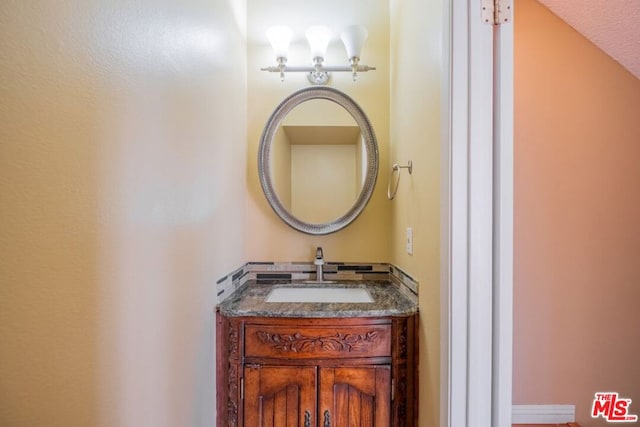 bathroom featuring vanity and lofted ceiling