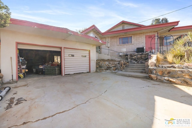 view of front of property with a garage and central AC unit