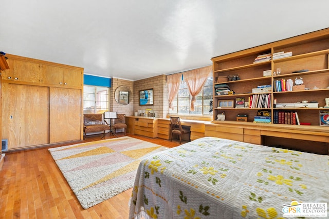 bedroom featuring light hardwood / wood-style floors and built in desk