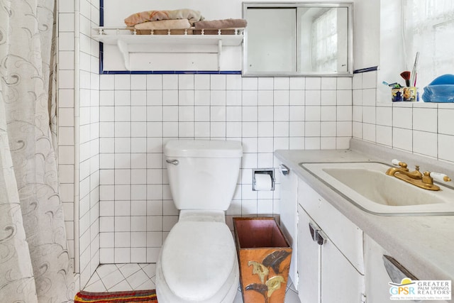 bathroom with tile walls, vanity, a shower with shower curtain, and toilet