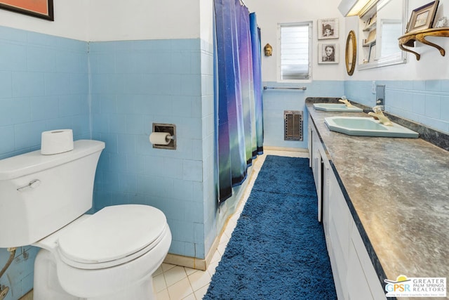 bathroom featuring curtained shower, toilet, tile patterned floors, tile walls, and vanity