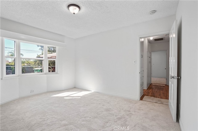 carpeted spare room with a textured ceiling