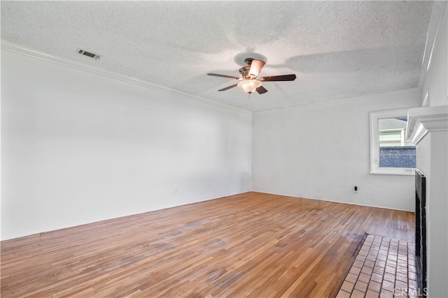 empty room with crown molding, ceiling fan, wood-type flooring, and a textured ceiling