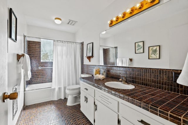 full bathroom featuring backsplash, vanity, tile patterned floors, toilet, and shower / bath combo with shower curtain