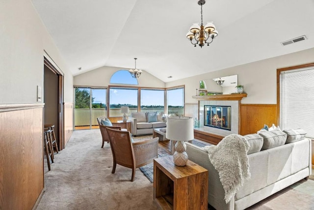 living room with an inviting chandelier, lofted ceiling, light carpet, and wood walls