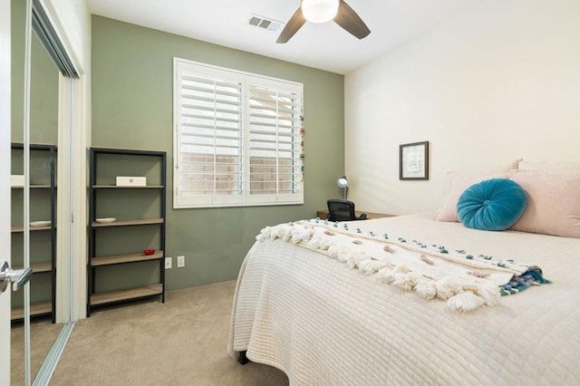 bedroom with ceiling fan, a closet, and light carpet