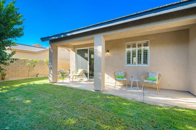 rear view of house featuring a yard and a patio area