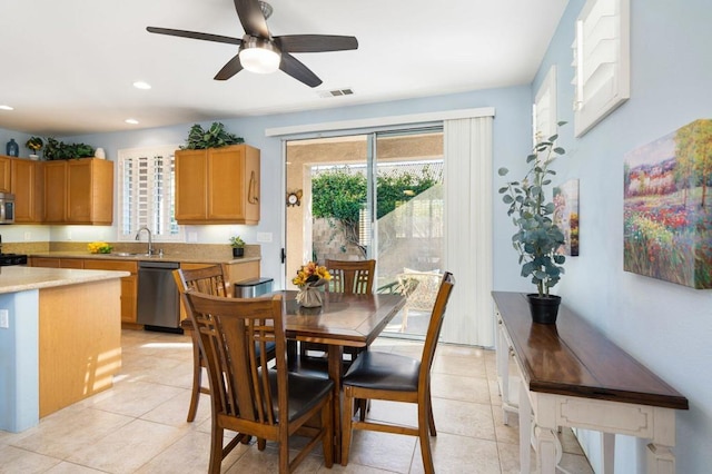 tiled dining area with ceiling fan and sink