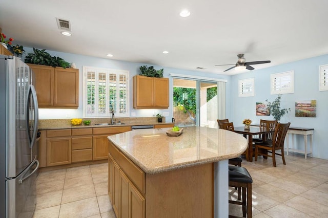 kitchen featuring a wealth of natural light, sink, a center island, and appliances with stainless steel finishes