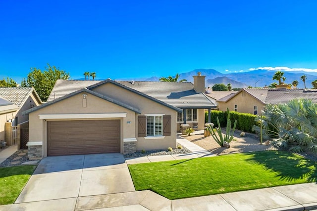 ranch-style house with a mountain view, a garage, and a front lawn