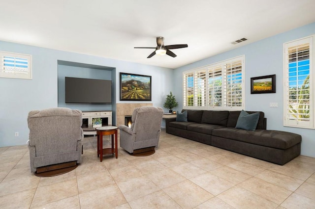 living room featuring ceiling fan, light tile patterned floors, and a wealth of natural light