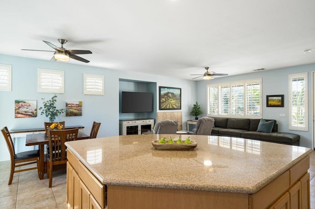 kitchen featuring ceiling fan, a kitchen island, and light tile patterned floors