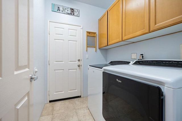 laundry room with cabinets, light tile patterned floors, and separate washer and dryer