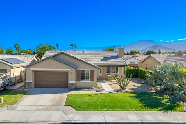 single story home featuring a mountain view, a garage, and a front yard