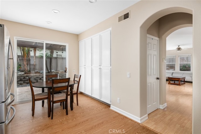 dining space with ceiling fan and light hardwood / wood-style flooring