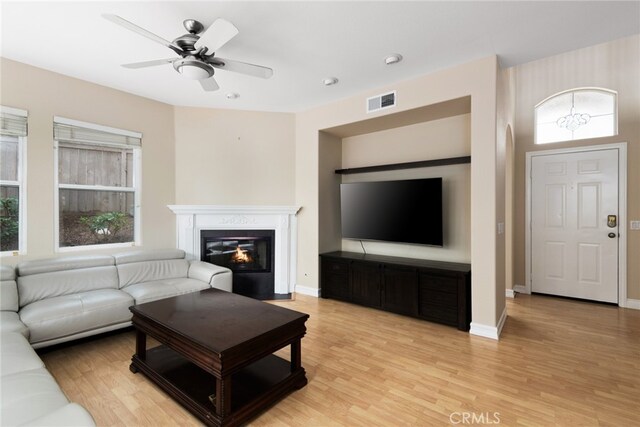 living room featuring light hardwood / wood-style flooring, a wealth of natural light, and ceiling fan