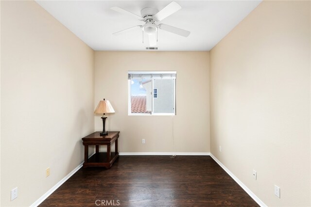 empty room with ceiling fan and dark hardwood / wood-style flooring