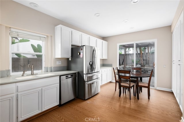 kitchen featuring white cabinetry, plenty of natural light, stainless steel appliances, and light wood-type flooring