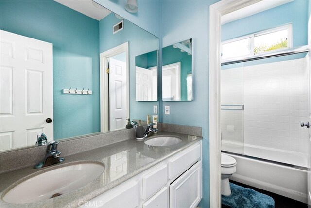 full bathroom featuring toilet, combined bath / shower with glass door, and vanity