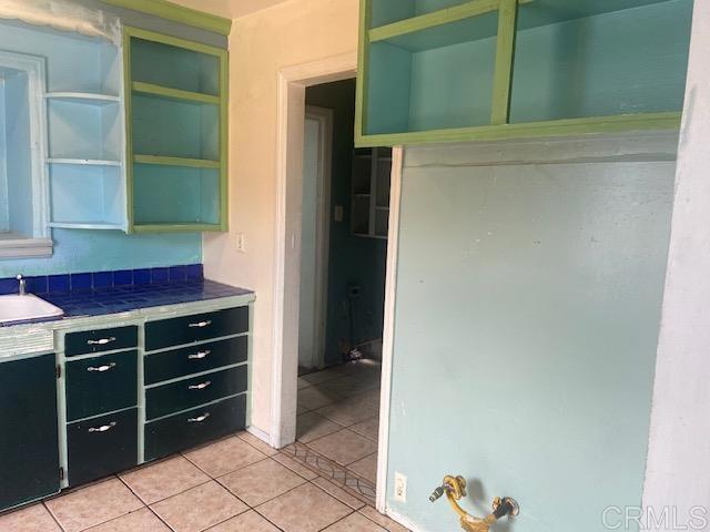 341 Brooks, Oceanside, CA 92054 - kitchen featuring open shelves, light tile patterned floors, dark cabinetry, and tile countertops
