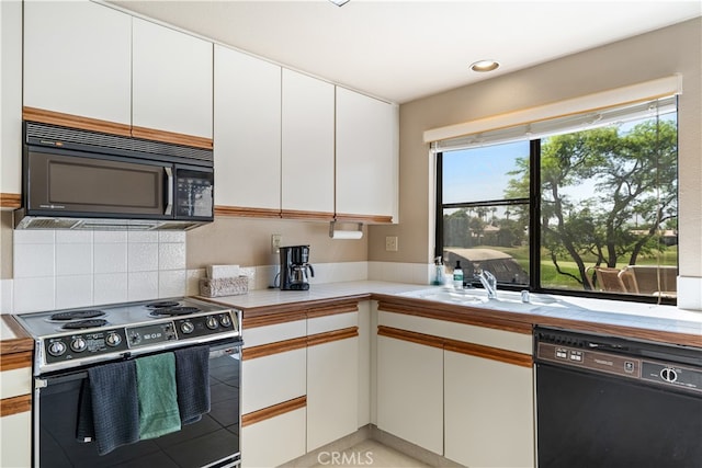 kitchen with black appliances, white cabinetry, and tasteful backsplash