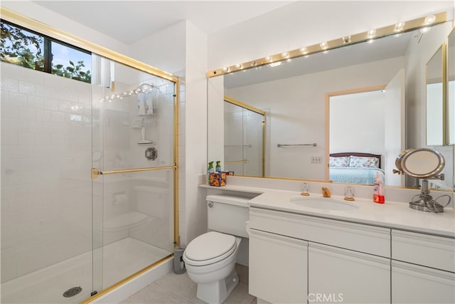 bathroom featuring tile patterned floors, toilet, vanity, and a shower with shower door