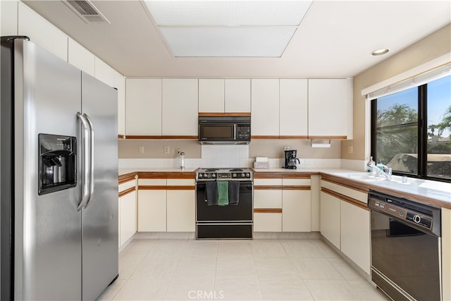 kitchen with white cabinets, black appliances, and sink