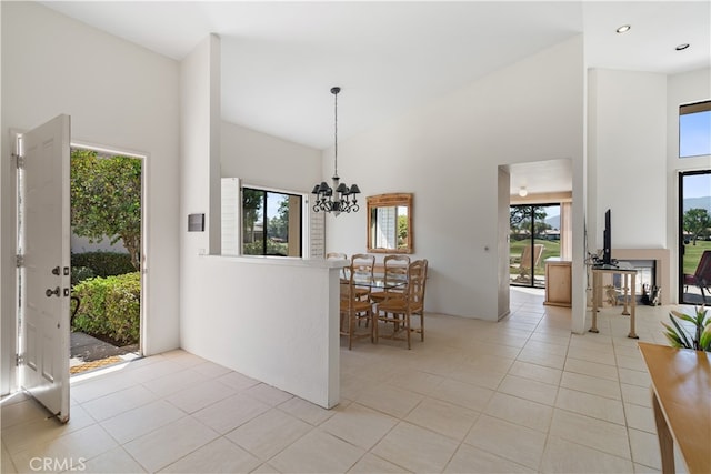 dining space featuring light tile patterned flooring, a notable chandelier, and a towering ceiling