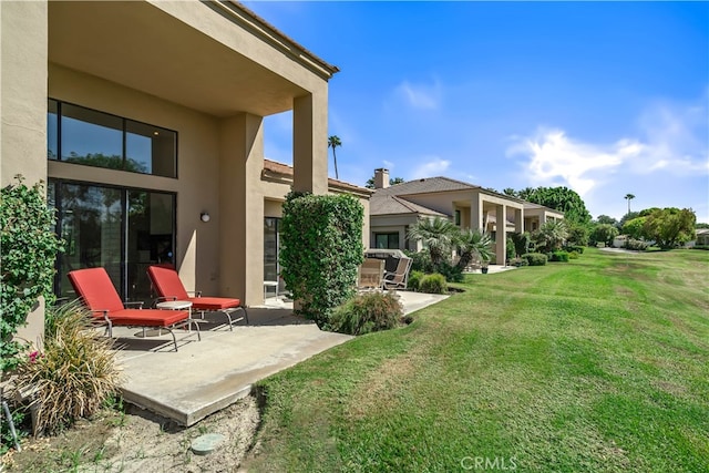 back of property with a yard and a patio area