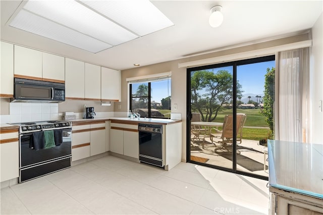 kitchen with black appliances, white cabinetry, and light tile patterned floors