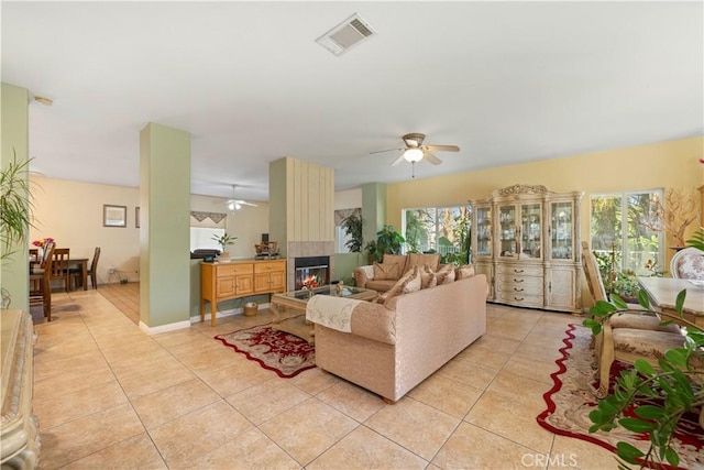 tiled living room with ceiling fan and a wealth of natural light