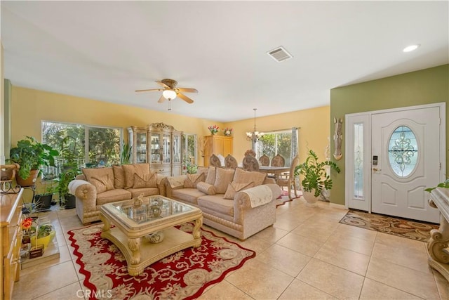 tiled living room featuring ceiling fan with notable chandelier