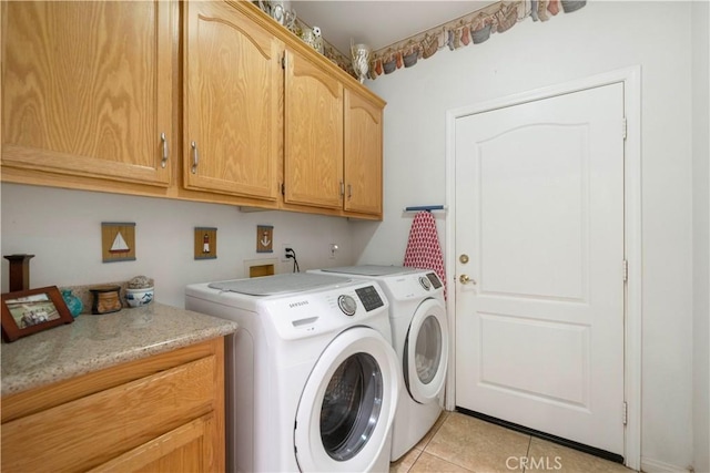 washroom featuring cabinets, light tile patterned floors, and washing machine and dryer