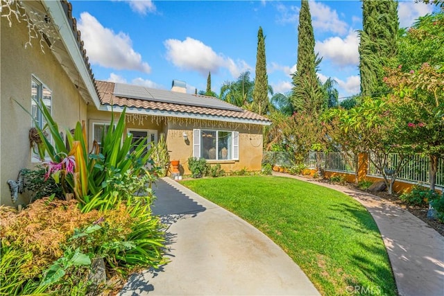 exterior space with a front yard and solar panels