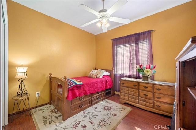 bedroom with dark hardwood / wood-style flooring and ceiling fan